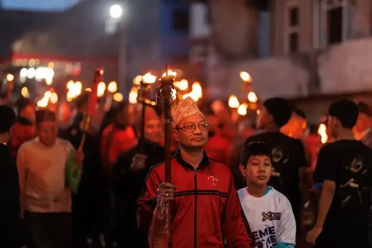 Man with ritual torch at a vibrant Biska Jatra festival in Bode, Nepal.