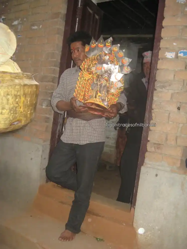 Man carrying a decorated idol during a religious festival in Tigani, Nepal.