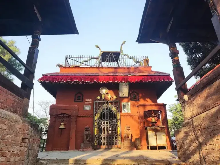 Temple entrance in Tigani, Nepal, featuring traditional architecture and religious decorations.