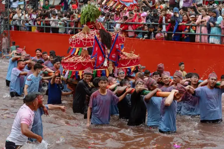 Participants wade through the river during the Biska Jatra festival in Nepal.