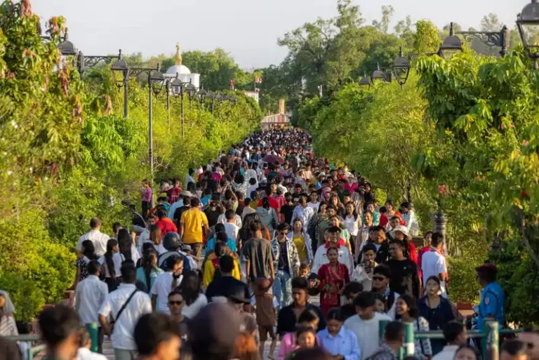 Crowd at a Nepal religious festival, celebrating Buddha Jayanti under lush trees.