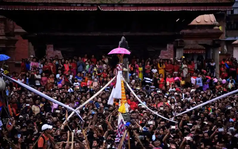 Crowd during Gai Jatra festival in Bhaktapur, Nepal, with a decorated palanquin.