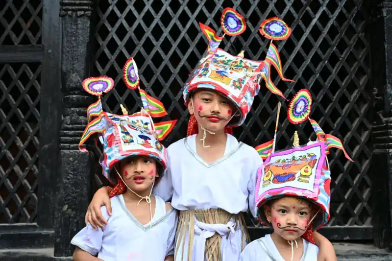 Children in elaborate masks celebrating Gai Jatra in Kathmandu, Nepal.