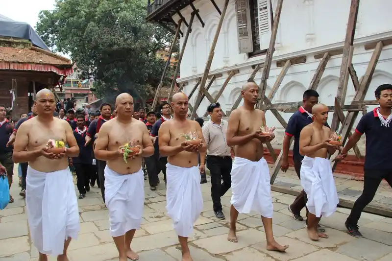 Men in white robes participate in a Gai Jatra festival in Kathmandu, Nepal.
