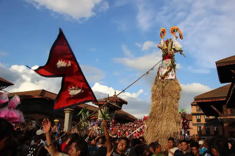 Kathmandu's Gai Jatra festival procession with vibrant flags and cultural traditions.