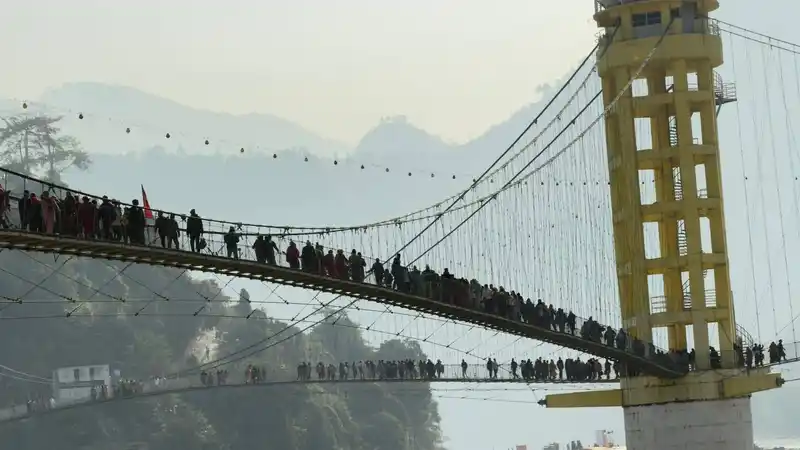 Crowds cross a suspension bridge during a Nepali festival in the Maghi Ridi Mela area.