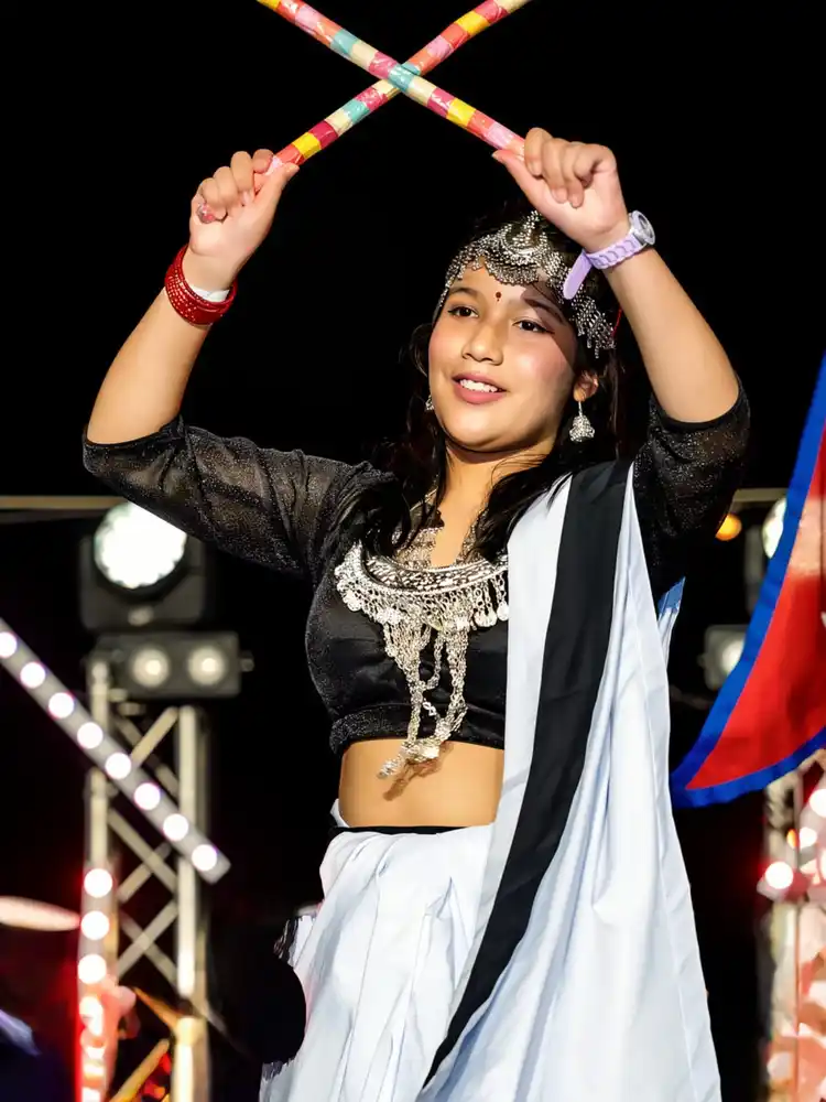 Nepali culture: Woman celebrating Maghe Sankranti with traditional festival sticks.