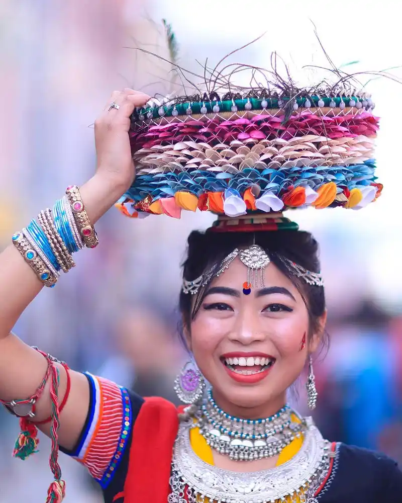 Woman celebrating Nepal's Maghe Sankranti festival with traditional headwear and jewelry.