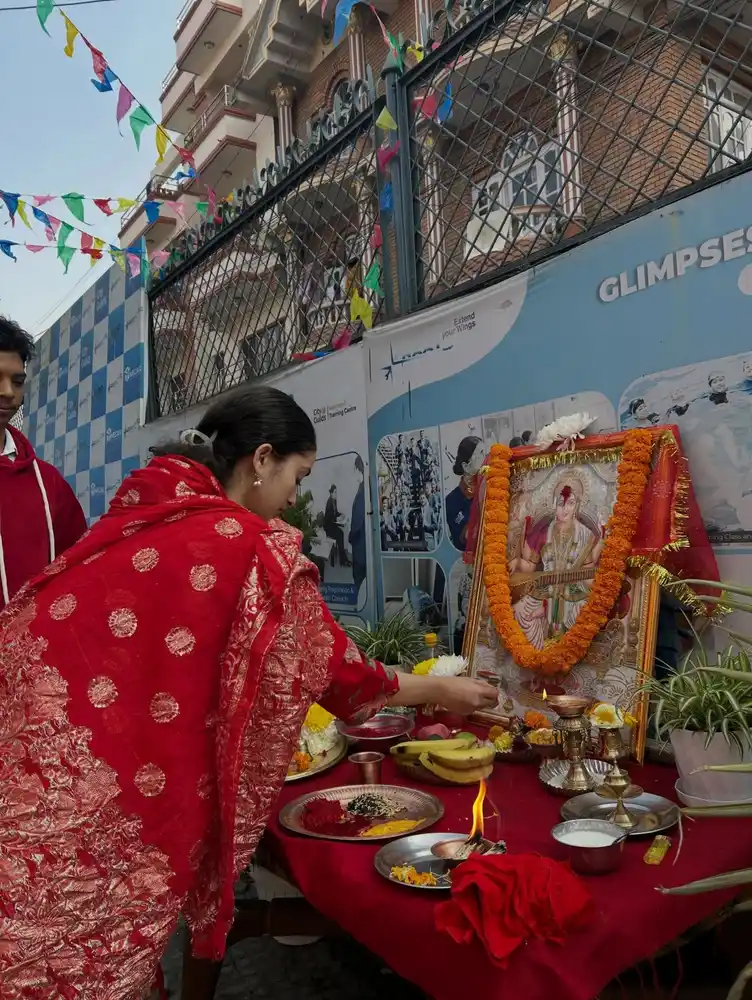 Woman preparing offerings for Saraswati Puja during Basanta Panchami in Nepal.