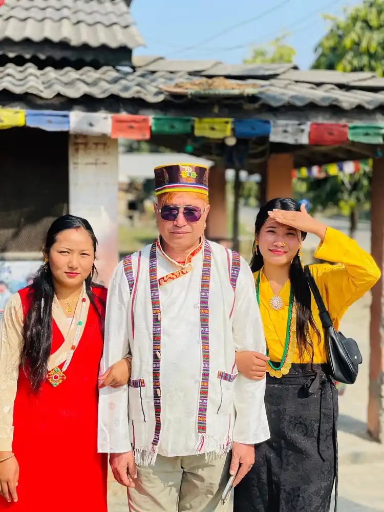Three people in traditional Nepali clothing attend a cultural festival in Nepal.