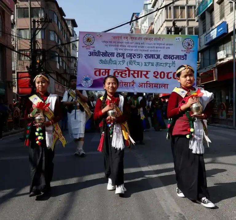 Three young participants in a Nepal Loshar festival procession on a city street.