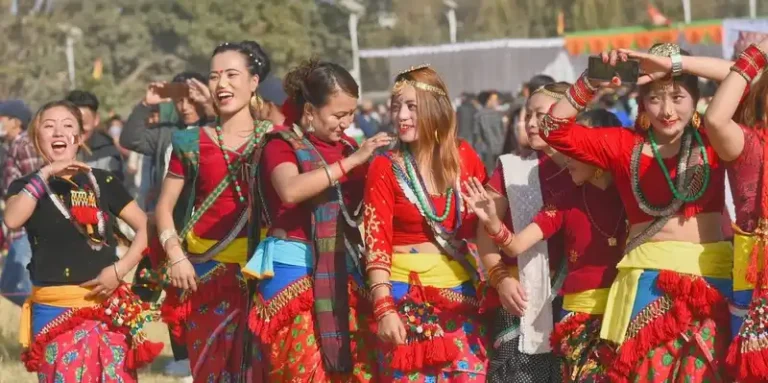 Joyful Kirat women celebrating Nepal's Ubhauli Parva festival in traditional attire.