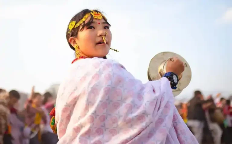 Young girl at Udhauli Parva Nepal Kirat festival, performing with cymbals.