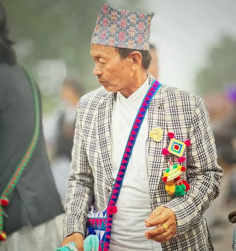 Kirat man celebrating Udhauli Parva in Nepal, wearing traditional festive attire and cap.