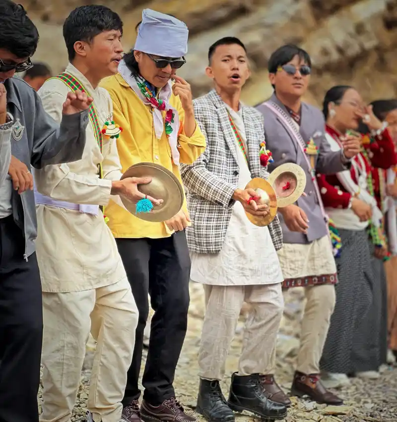 Kirat men celebrating Udhauli Parva in Nepal, performing traditional festival rituals.